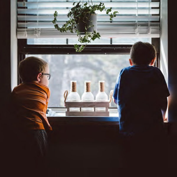 two little kids looking out the window