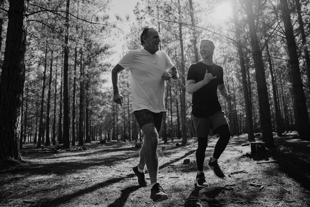 two men smiling and chatting on a run